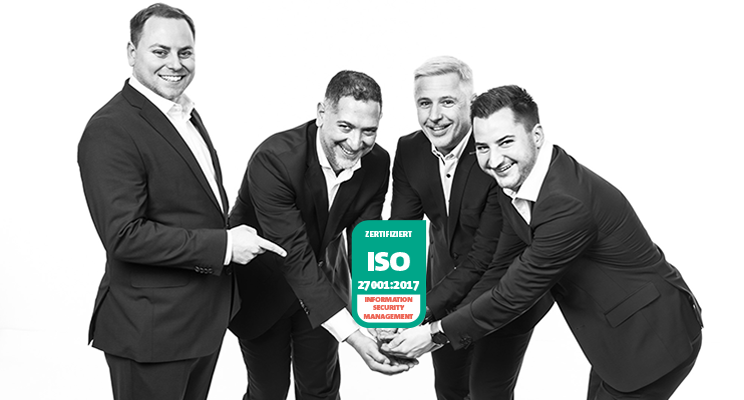 vier Mitarbeiter halten das DIN ISO 27001 Zertifikat